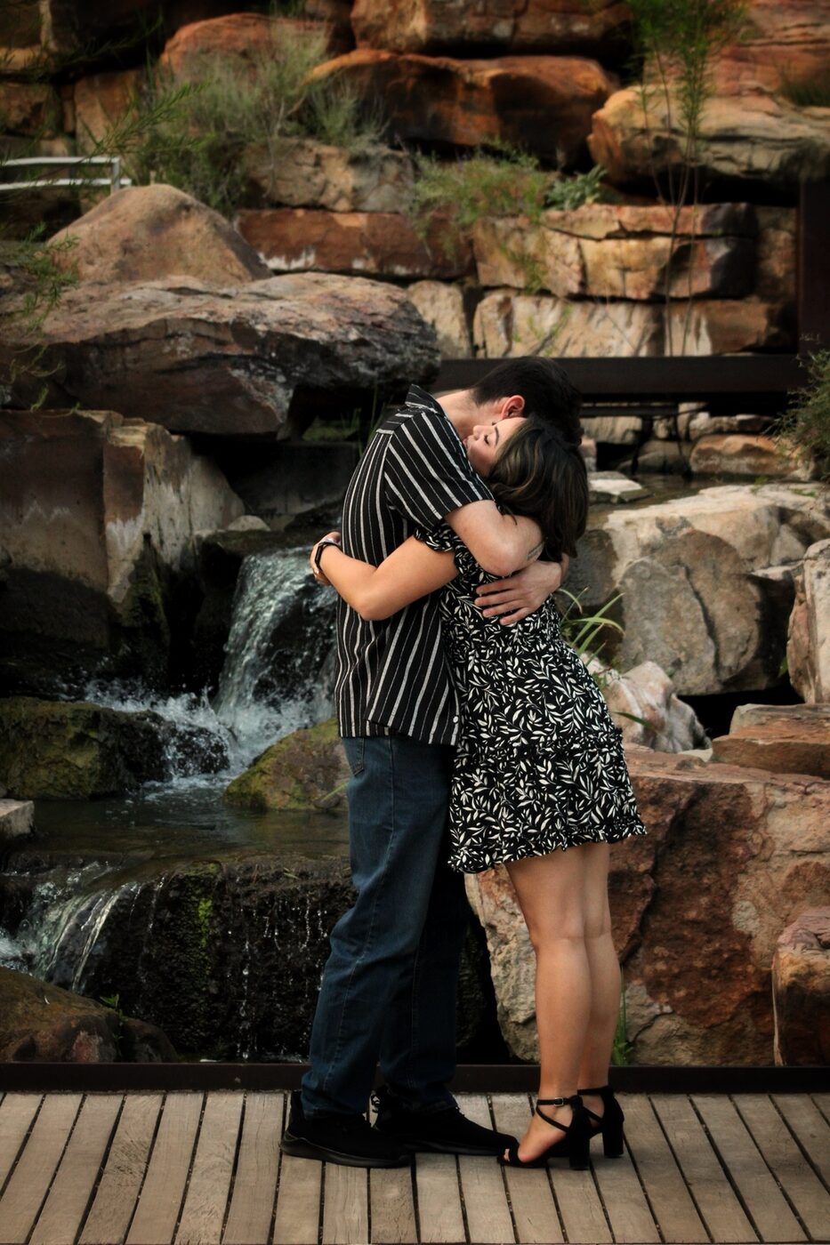 Couple embracing beside a waterfall