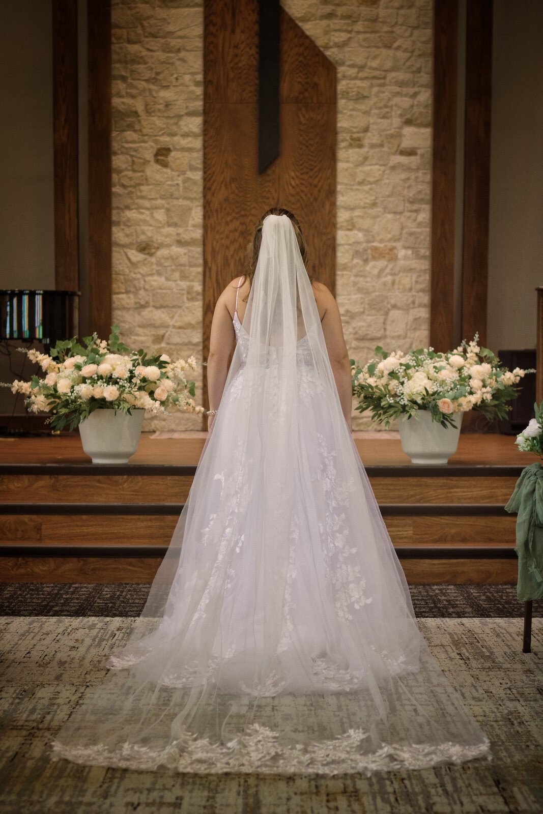 Bride standing at the altar, veil catching soft light