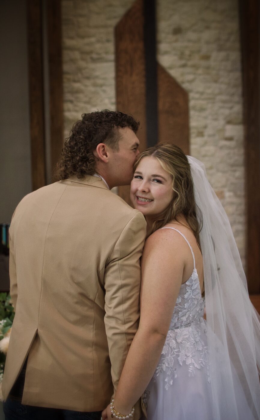 Groom kissing bride's cheek