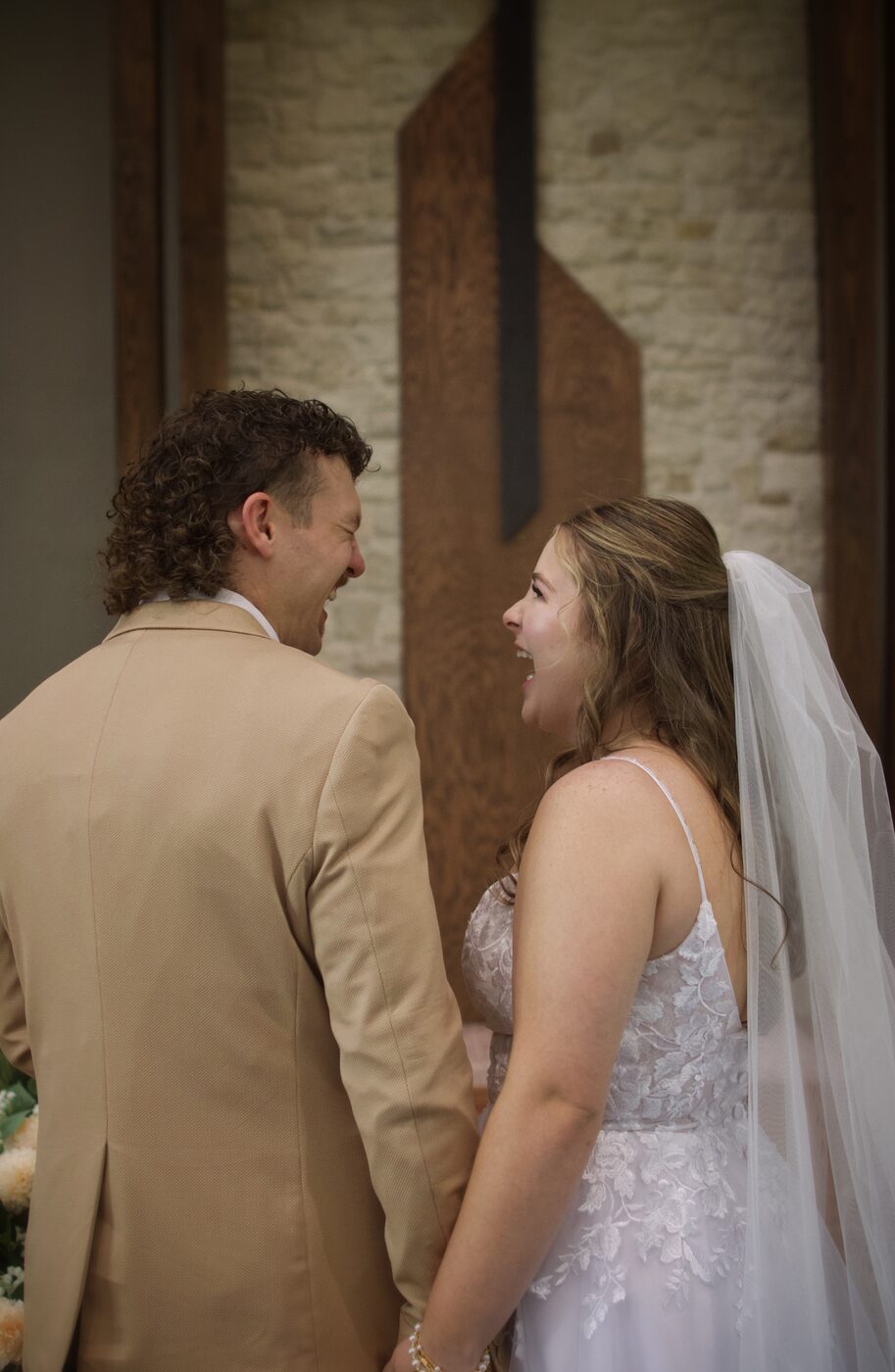 Bride and groom laughing together, backs to camera